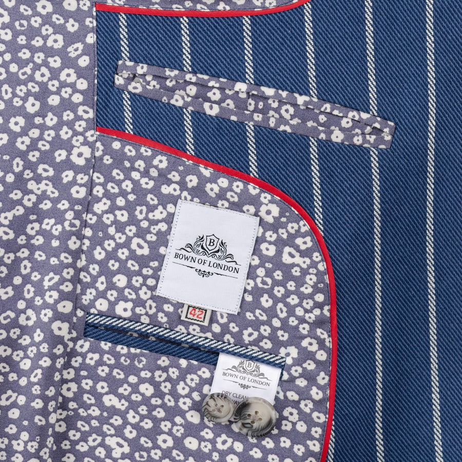 Close-up of a shirt with floral pocket square and 'Bown of London' label on a blue and white striped background.