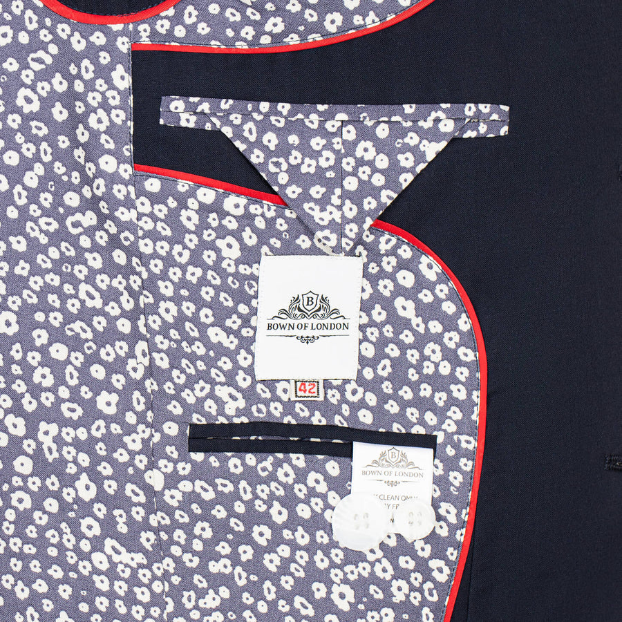 Close-up of a suit jacket with a floral pattern and a brand label on a dark background