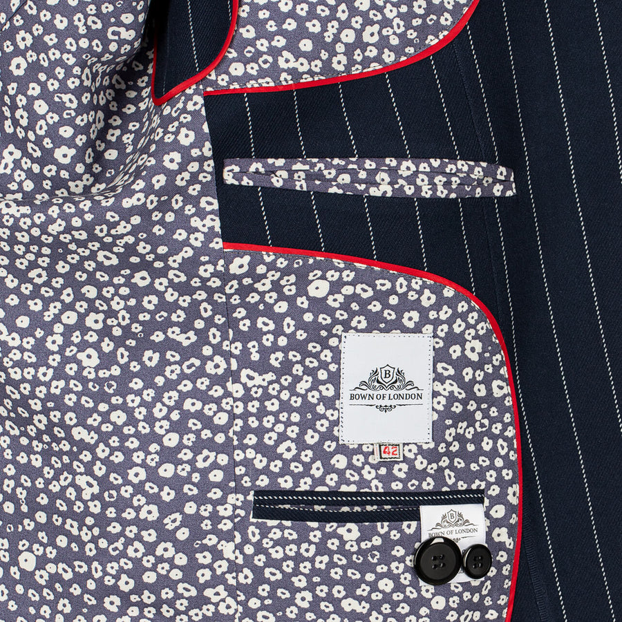 Close-up of a suit jacket with floral pattern and pinstripes, featuring a brand label.