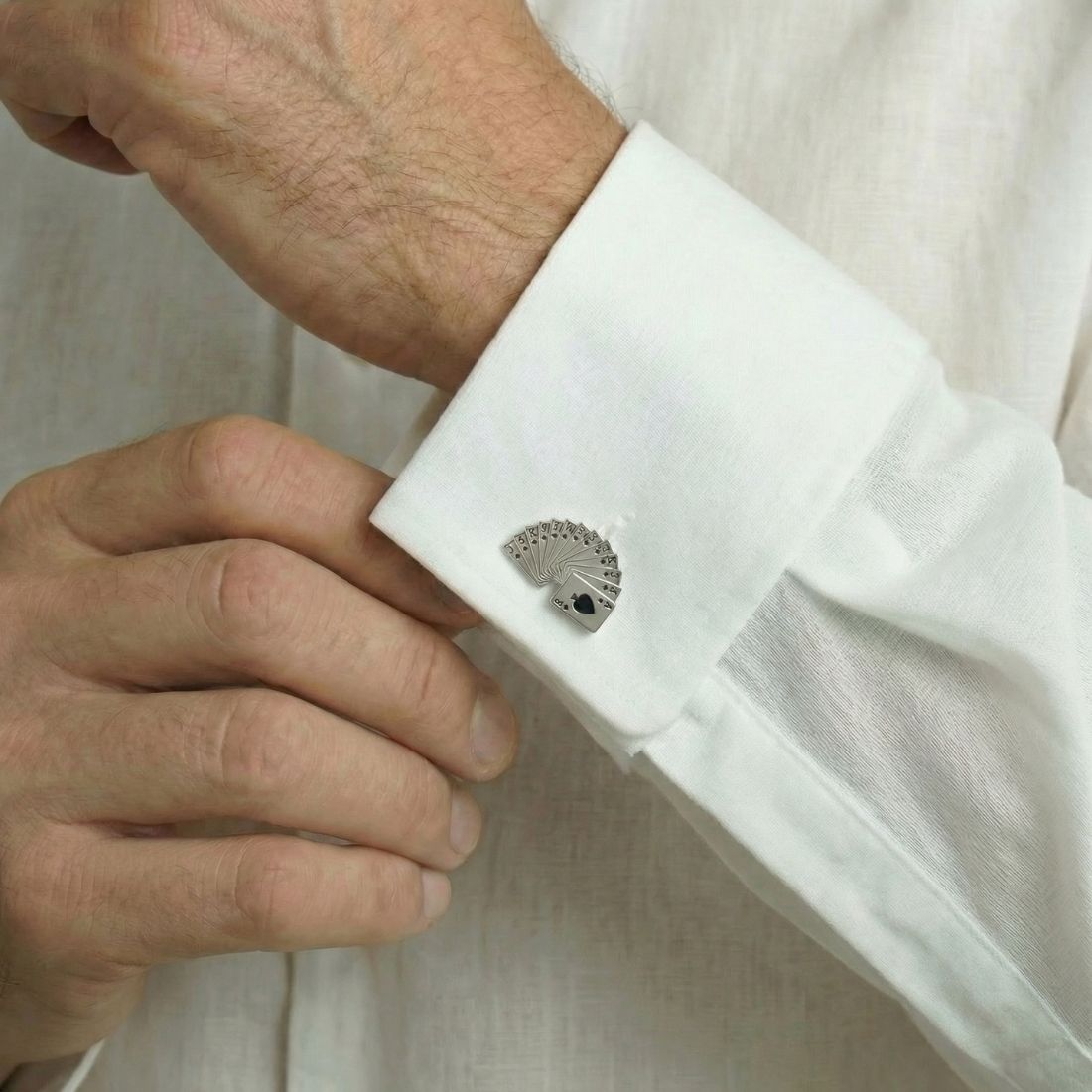 Cufflink on a white shirt cuff with a neutral background. Bown of London.