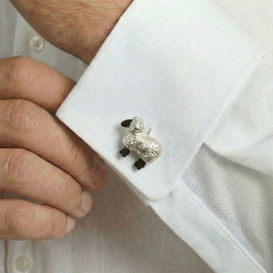 Cufflink shaped like a sheep on a white shirt cuff. Bown of London.