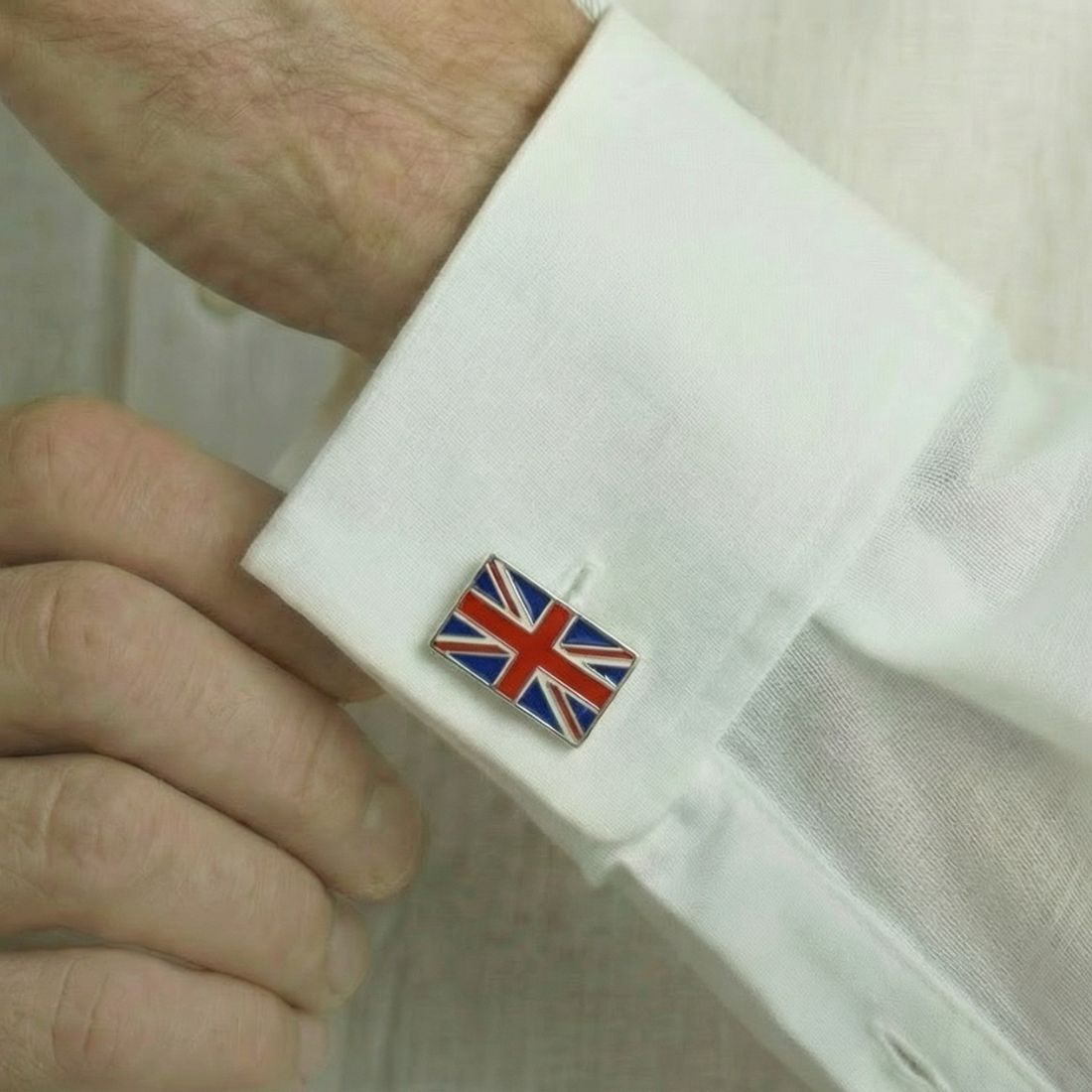 Cufflink with British flag design on a white shirt cuff. Bown of London